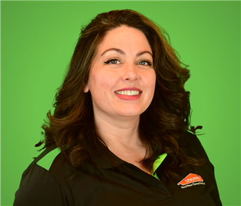 Female SERVPRO Employee smiling in front of a beige wall.